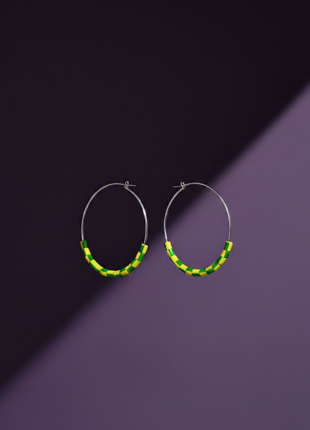 Electric Dream yellow green hoop earrings – Trash Panda upcycled jewellery 2026 – Louise Lea (14) A pair of silver tone hoop earrings with yellow and green beads made from upcycled materials, on a purple background