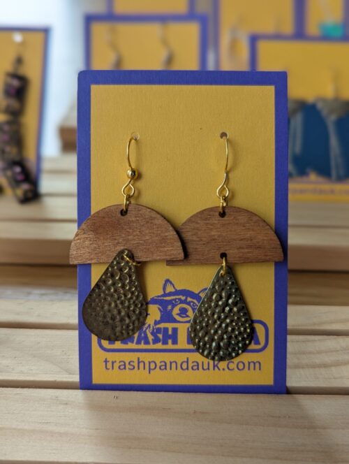 A close up photo of a pair of mushroom-shaped earrings on a jewellery display card
