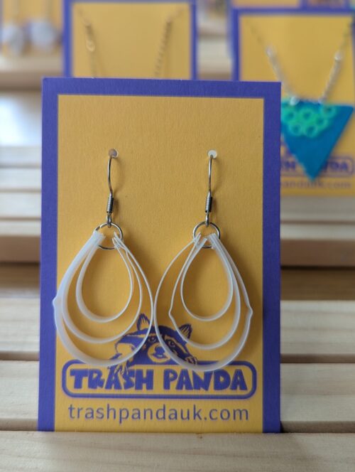 Earrings with white teardrop shaped pendants made from upcycled plastic
