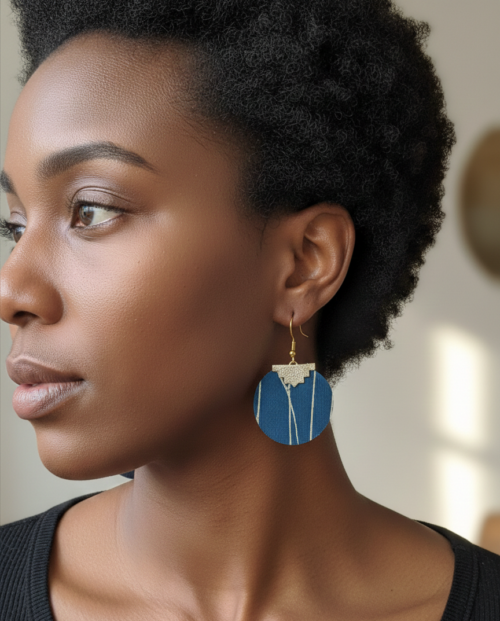 A black woman facing away to show her blue and gold earrings made from upcycled roller blind material
