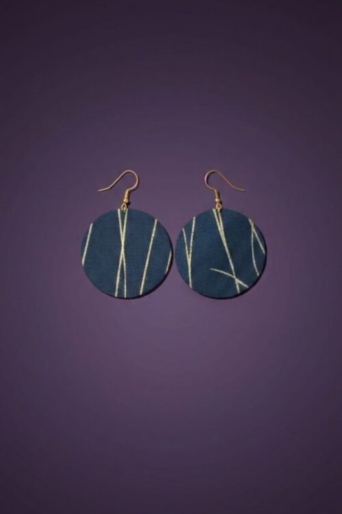 A pair of blue and gold earrings, against a purple backdrop